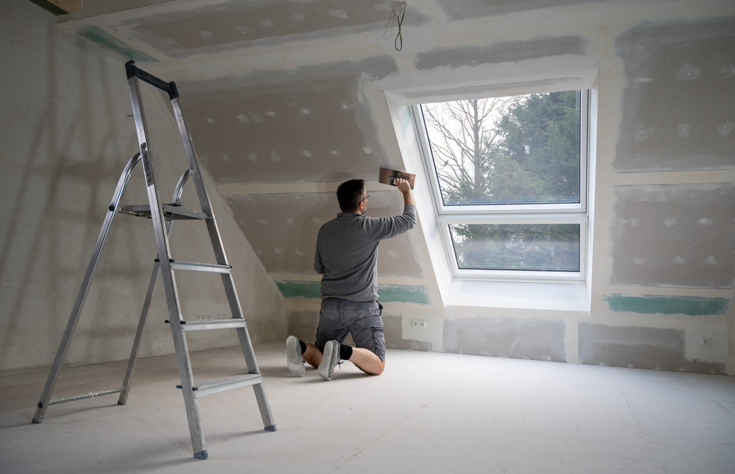 Man plastering drywall in a private house.